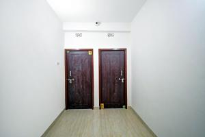 twee bruine deuren in een kamer met een houten vloer bij OYO Hotel Grand Eden in Calcutta
