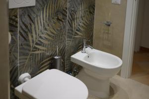 フィウミチーノにあるLoft Sea&Sky Fiumicino Airportの白いトイレと洗面台のあるバスルーム +20枚の写真