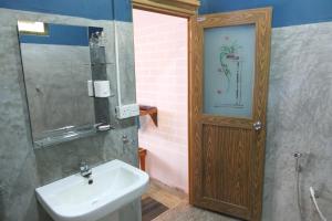 ein Badezimmer mit einem Waschbecken und einer Holztür in der Unterkunft Summer Villa Ella in Ella