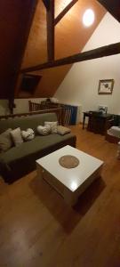 a living room with a green couch and a coffee table at Gîte de la liberté in Sainte-Marie-du-Mont