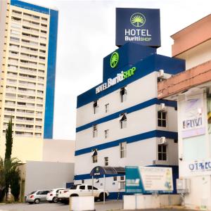 ein Hotelgebäude mit auf einem Parkplatz geparkt in der Unterkunft Hotel Buriti Shop in Goiânia