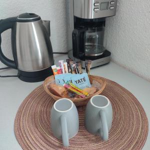 a basket of food and two cups on a counter with a coffee maker at Neoresid - Résidence du Parc in Reims