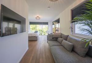 uma sala de estar com um sofá e uma televisão de ecrã plano em 't Kleine eiland em Zuid-Scharwoude