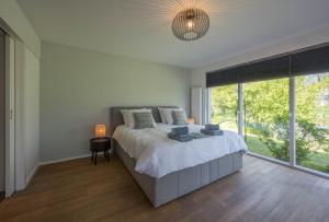 um quarto com uma cama e uma grande janela em 't Kleine eiland em Zuid-Scharwoude