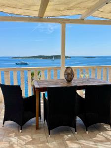a wooden table on a balcony with a view of the ocean at Apartment MORE Island Vis in Vis