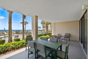 a patio with a table and chairs and the ocean at Bluewater Unit 104 in Orange Beach