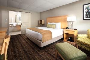 una habitación de hotel con una cama grande y una silla en Bar Harbor Villager Motel - Downtown, en Bar Harbor