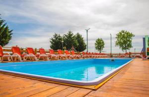 - une piscine avec des chaises sur une terrasse en bois dans l'établissement Voila Mamaia, à Mamaia 27 autres photos