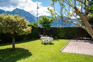 a table and chairs in a yard with mountains at Casa Daria in Levico Terme