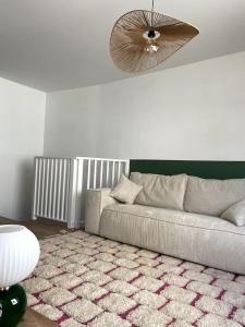 a living room with a couch and a fan at Appartement en hyper centre in Étaples