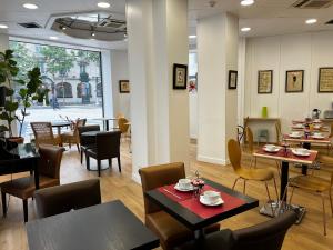 - un restaurant avec des tables et des chaises dans une salle dans l'établissement Hotel Viator - Gare de Lyon, à Paris