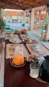 una mesa larga con platos de comida y bebidas. en Pousada rancho sol nascente, en Tutóia