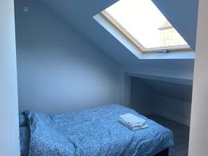 a blue bedroom with a bed with two towels on it at Croydon Victorian 1-Bed Penthouse Sleeps 2 in London