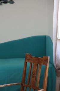 una silla de madera frente a un sofá verde en Villa Puolo - With Private Sea Access en Sorrento