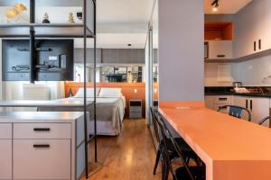 eine Küche und ein Schlafzimmer mit einem Bett in einem Zimmer in der Unterkunft Incrível Studio 308 - Batel CWB (melhor localização) in Curitiba