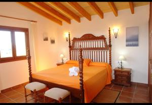 a bedroom with an orange bed with two chairs at Finca Sa Torre Nova in Son Carrió