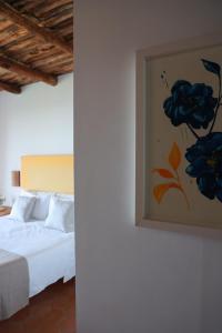 a bedroom with a bed with a painting on the wall at Villa Puolo - With Private Sea Access in Sorrento