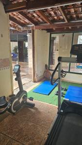 a room with a gym with a treadmill and blue mats at Area de lazer Lua e Sol in Franca