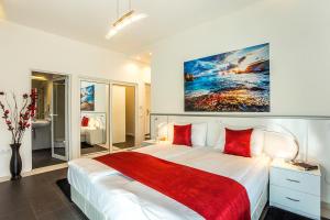 a bedroom with a large white bed with red pillows at Complex Europe in Dolna Banya +62 photos