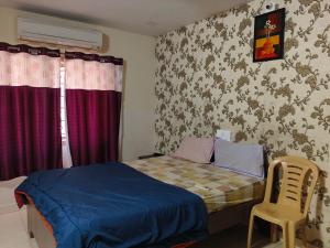 ein kleines Schlafzimmer mit einem Bett und einem Stuhl in der Unterkunft Sri Krishna Residency in Visakhapatnam