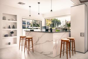 uma cozinha com um balcão de mármore e bancos em Danae Hotel em Egina