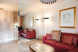 un soggiorno con divano rosso e tavolo di Residenza Porto Fino App 7000 a Brissago