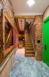 un pasillo con una puerta verde y una pared de ladrillo en Apart View Hotel & Spa en Tiflis