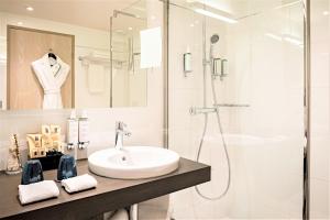 La salle de bains est pourvue d'un lavabo et d'une douche. dans l'établissement Hotel Croisette Beach Cannes - Mgallery, à Cannes