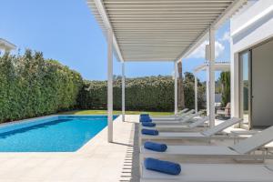 a patio with lounge chairs and a swimming pool at Villa Marc II in Sant Jordi