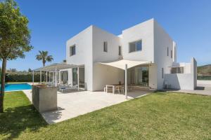 a white villa with a pool and lawn at Villa Marc II in Sant Jordi