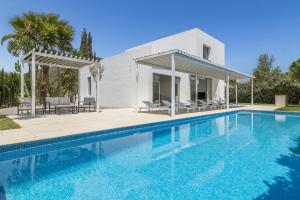 a swimming pool in front of a white house at Villa Marc II in Sant Jordi