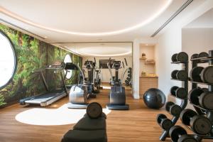 einen Fitnessraum mit Trainingsgeräten und Wandmalereien in der Unterkunft Hotel Croisette Beach Cannes - Mgallery in Cannes