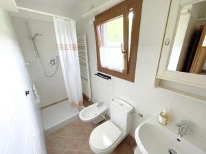 a white bathroom with a toilet and a sink at Tre Terre in Mulazzo +6 photos