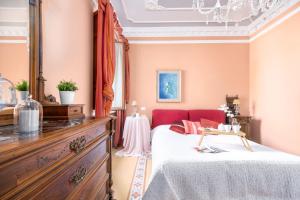 a bedroom with a bed and a red chair at Villino Simona in Viareggio