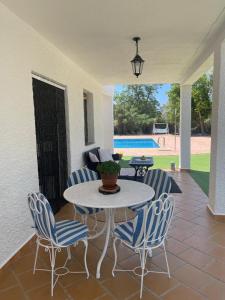 a patio with a table and chairs and a pool at Villa Marichu. Piscina, BBQ y a 15 min Puy du Fou in Totanés