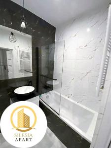 a bathroom with a shower and a white marble wall at Apartament Zielony in Tychy