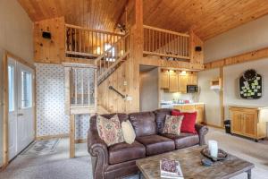 a living room with a brown couch and a wooden ceiling at Serenity Ridge Retreat in Lead