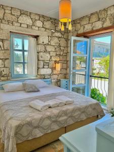 1 dormitorio con 1 cama grande y 2 ventanas en Dort Mevsim Alacati, en Alacati