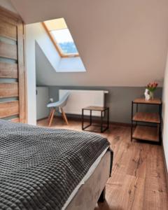 ein Schlafzimmer mit einem Bett und einem Dachfenster in der Unterkunft Domek Pierwiosnek Ustroń in Ustroń