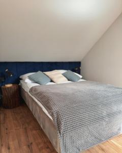 sypialnia z dużym łóżkiem z niebieskimi ścianami w obiekcie Domek Pierwiosnek Ustroń w Ustroniu