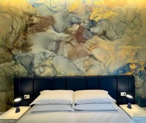 a bed in front of a wall with a painting at Le Dimore di Lorenzo in Naples