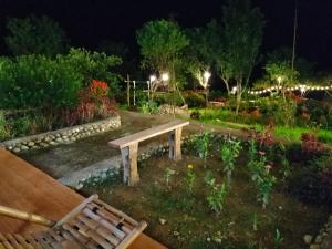 a park bench in a garden at night at Muong Hoa Hmong Homestay in Sa Pa