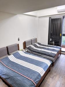 twee bedden in een kamer met een raam bij Yun B&B in Dongshan