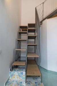 uma escada de metal num quarto com piso em azulejo em PALAZZO PELLEGRINO vietri em Vietri