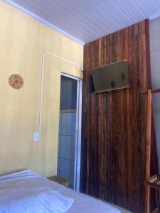1 dormitorio con 1 cama y TV en la pared en Pousada rancho sol nascente, en Tutóia