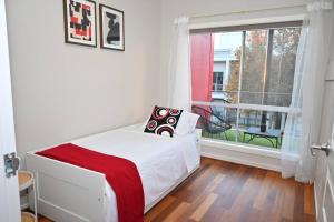a white bedroom with a bed and a window at Mawson Red - Free Pool access -Onsite Parking-Netflix-5 mins to Mawson Interchange in Mawson Lakes +22 photos