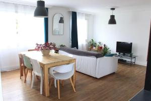 een woonkamer met een tafel en een bank bij Maison et jardin à 5 min de Vannes in Meucon