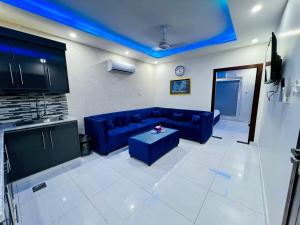 sala de estar con sofá azul y mesa en Premier Heights Jhelum, en Jhelum