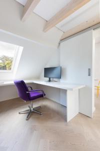 ein Büro mit einem Schreibtisch und einem lila Stuhl in der Unterkunft HOMEFY - Luxury Art Apartment in Düsseldorf + 3 Fotos
