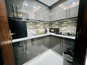 una cocina con armarios de acero inoxidable y fregadero en Premier Heights Jhelum en Jhelum